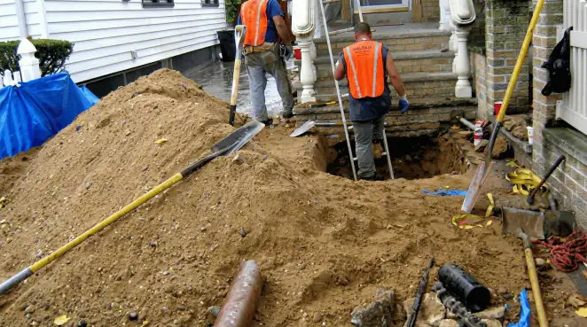 Contractors performing foundation protection and exterior drainage excavation near residential home steps in Santa Ana, CA
